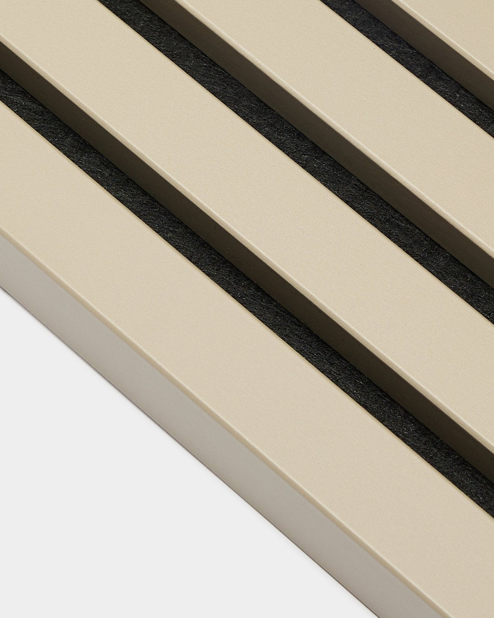 Close-up van WoodUpp Akupanel eindlamel in Stone, 2,2 cm—beige akoestische latten met black tussenruimtes op een witte achterplaat, geschikt voor MDF-frame-paneelwanden.